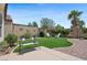 Beautiful backyard with artificial grass, brick patio, and lush landscaping perfect for outdoor enjoyment at 2425 Sturrock Dr, Henderson, NV 89044