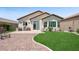 Charming backyard with a well-kept lawn, brick patio, and ample seating for enjoying the outdoors at 2425 Sturrock Dr, Henderson, NV 89044