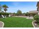 Lush backyard featuring artificial grass, a brick patio, and inviting seating arrangements at 2425 Sturrock Dr, Henderson, NV 89044