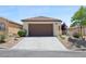 A well-maintained home featuring a two-car garage and desert landscaping at 2425 Sturrock Dr, Henderson, NV 89044