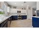 This is a kitchen with stainless steel appliances, white and blue cabinets, and a tile backsplash at 2425 Sturrock Dr, Henderson, NV 89044