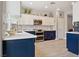 This is a kitchen with stainless steel appliances, white and blue cabinets, and a tile backsplash at 2425 Sturrock Dr, Henderson, NV 89044