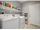 Well-equipped laundry room with modern washer and dryer units and convenient overhead storage at 2425 Sturrock Dr, Henderson, NV 89044