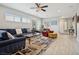 Bright living room features a ceiling fan, a comfortable sofa, and a decorative area rug at 2425 Sturrock Dr, Henderson, NV 89044