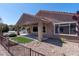 Backyard with desert landscaping, wrought-iron fencing, covered patio, and artificial turf at 2538 Capella Star St, Henderson, NV 89044