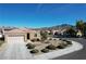Front exterior with desert landscaping, bushes and rock, plus a three-car garage at 2538 Capella Star St, Henderson, NV 89044