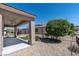 Covered patio with desert landscaping, small turf area, and ceiling fan at 2538 Capella Star St, Henderson, NV 89044