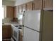 Kitchen featuring white appliances, including a refrigerator, oven, microwave, and light wood cabinets at 2725 S Nellis Blvd # 1158, Las Vegas, NV 89121