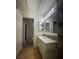 Bright bathroom with a long vanity, big mirror with vanity lights, and storage shelves at 2995 E Sunset Rd # 237, Las Vegas, NV 89120