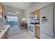Bright kitchen features white appliances, light wood cabinetry, and backyard access at 3320 Cactus Shadow St # 201, Las Vegas, NV 89129