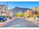 A straight on view of a neighborhood street surrounded by attached homes and desert landscaping at 3320 Cactus Shadow St # 201, Las Vegas, NV 89129