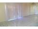 Bright living room featuring large sliding doors, light walls, and tiled floors, illuminated by a chandelier at 3435 Villa Knolls South Dr, Las Vegas, NV 89120