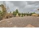 Landscaped backyard with gravel, shrubs, and decorative windmill feature at 3473 Conough Ln, Las Vegas, NV 89129