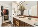 Well-lit bathroom with dual sinks, wooden cabinets, and walk-in closet at 3473 Conough Ln, Las Vegas, NV 89129