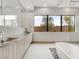 Elegant bathroom with dual sinks, decorative tile, soaking tub and backyard views at 3510 Cosima Ln, Las Vegas, NV 89120
