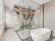 Modern bathroom featuring a freestanding tub and walk-in glass shower with decorative tile accent at 3510 Cosima Ln, Las Vegas, NV 89120