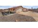 Backyard home exterior with stucco walls, orange tile roof, covered patio, and desert rock groundcover at 411 Monmouth Ct, Henderson, NV 89015