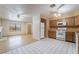 Bright kitchen with wooden cabinets, white appliances, and tile flooring at 411 Monmouth Ct, Henderson, NV 89015