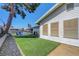 Spacious backyard with lawn, patio area, and mature shade tree and storage on the side at 4445 Peterson Dr, Las Vegas, NV 89103