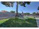 A backyard featuring artificial turf, a large shade tree, and a block fence at 4445 Peterson Dr, Las Vegas, NV 89103