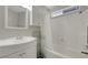 Full bathroom featuring a vanity sink, shower-tub combo and a window for natural light at 4445 Peterson Dr, Las Vegas, NV 89103