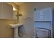 Compact bathroom with pedestal sink, storage cabinet, and toilet at 4445 Peterson Dr, Las Vegas, NV 89103