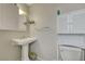 Modest bathroom featuring a pedestal sink, mirrored vanity, and toilet with storage at 4445 Peterson Dr, Las Vegas, NV 89103