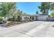 This single-story home has mature vegetation and an extra wide driveway leading to the garage at 4445 Peterson Dr, Las Vegas, NV 89103