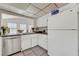 Kitchen featuring white cabinets, stainless steel dishwasher, and a view into the living room at 4445 Peterson Dr, Las Vegas, NV 89103