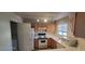 Functional kitchen featuring white appliances, wood cabinetry and an adjacent laundry area at 4555 Sahara Ave # 252, Las Vegas, NV 89104