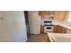 Functional kitchen featuring white appliances, wood cabinetry and an adjacent laundry area at 4555 Sahara Ave # 252, Las Vegas, NV 89104