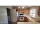 Functional kitchen featuring white appliances, wood cabinetry and an adjacent laundry area at 4555 Sahara Ave # 252, Las Vegas, NV 89104