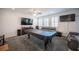 Inviting living area featuring sofas, a pool table, and a large TV at 4652 Wyncrest Ave, Las Vegas, NV 89115