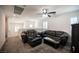 Spacious living room featuring plush black leather seating, ceiling fan, and bright natural light at 4652 Wyncrest Ave, Las Vegas, NV 89115
