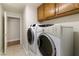 Convenient laundry room featuring a washer and dryer with storage cabinets above at 4904 Wiltondale Way, Las Vegas, NV 89130
