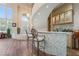 Elegant home bar beneath a curved staircase with a mosaic front, seating for two, and custom wine and glass storage at 5186 San Milano Ave, Las Vegas, NV 89141
