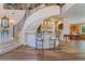 Stunning home bar area with mosaic tile and two bar stools, situated beneath a grand staircase and adjacent to the kitchen at 5186 San Milano Ave, Las Vegas, NV 89141
