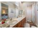 Bathroom with double sinks, wood cabinets, large mirrors, and a separate shower/toilet room for convenience at 5186 San Milano Ave, Las Vegas, NV 89141