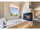 This bathroom features a soaking tub, a fireplace, and an exterior view at 5186 San Milano Ave, Las Vegas, NV 89141
