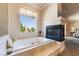 This bathroom features a soaking tub, a fireplace, and an exterior view at 5186 San Milano Ave, Las Vegas, NV 89141