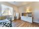 Minimalist bedroom featuring light walls, wood-look floors, a bed, desk, wardrobe, and ample natural light at 5186 San Milano Ave, Las Vegas, NV 89141