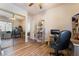 Cozy bedroom features wood flooring, a large mirror sliding closet door, and a ceiling fan at 5186 San Milano Ave, Las Vegas, NV 89141