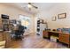 Bright home office featuring wood flooring, a ceiling fan, and built-in shelving and desk space at 5186 San Milano Ave, Las Vegas, NV 89141