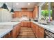 Spacious kitchen with wooden cabinetry, tile backsplash, stainless appliances and counter seating at 5186 San Milano Ave, Las Vegas, NV 89141