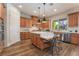 Bright kitchen features an island with seating, stainless steel appliances, and wood cabinets at 5186 San Milano Ave, Las Vegas, NV 89141