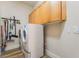 Functional laundry room featuring a washer and dryer set and upper cabinets for storage at 5186 San Milano Ave, Las Vegas, NV 89141