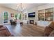 Inviting living room featuring a stone fireplace, built-in shelving, a large window, and comfortable seating at 5186 San Milano Ave, Las Vegas, NV 89141