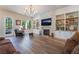 Inviting living room featuring a stone fireplace, built-in shelving, a large window, and comfortable seating at 5186 San Milano Ave, Las Vegas, NV 89141