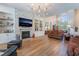 Spacious living room with a stone fireplace, built-in shelving, hardwood floors, and elegant chandelier at 5186 San Milano Ave, Las Vegas, NV 89141