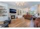Spacious living room with a stone fireplace, built-in shelving, hardwood floors, and elegant chandelier at 5186 San Milano Ave, Las Vegas, NV 89141